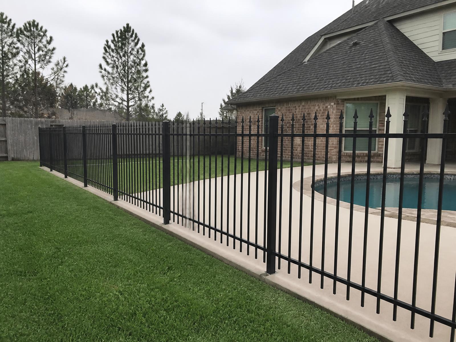 Black powder-coated ornamental iron pool fence around a backyard pool in Cypress, TX