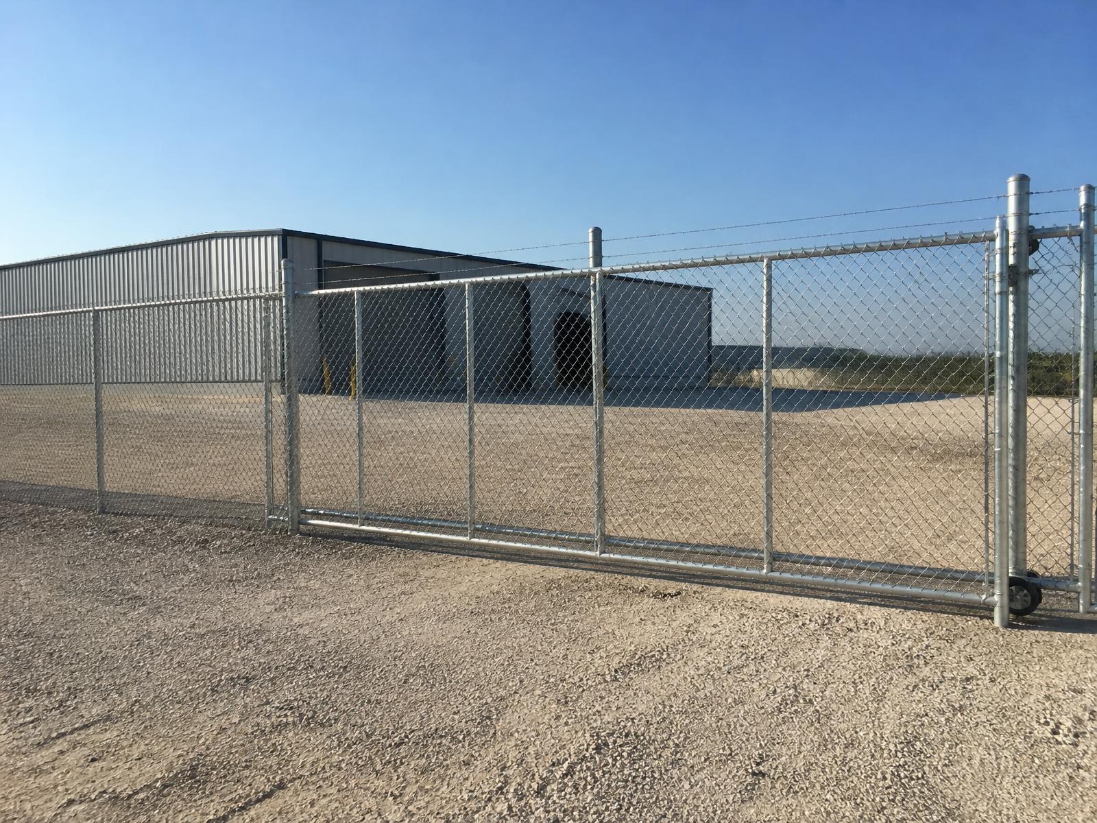 Galvanized commercial chain link security fence with rolling gate at a warehouse yard in Pearland, TX